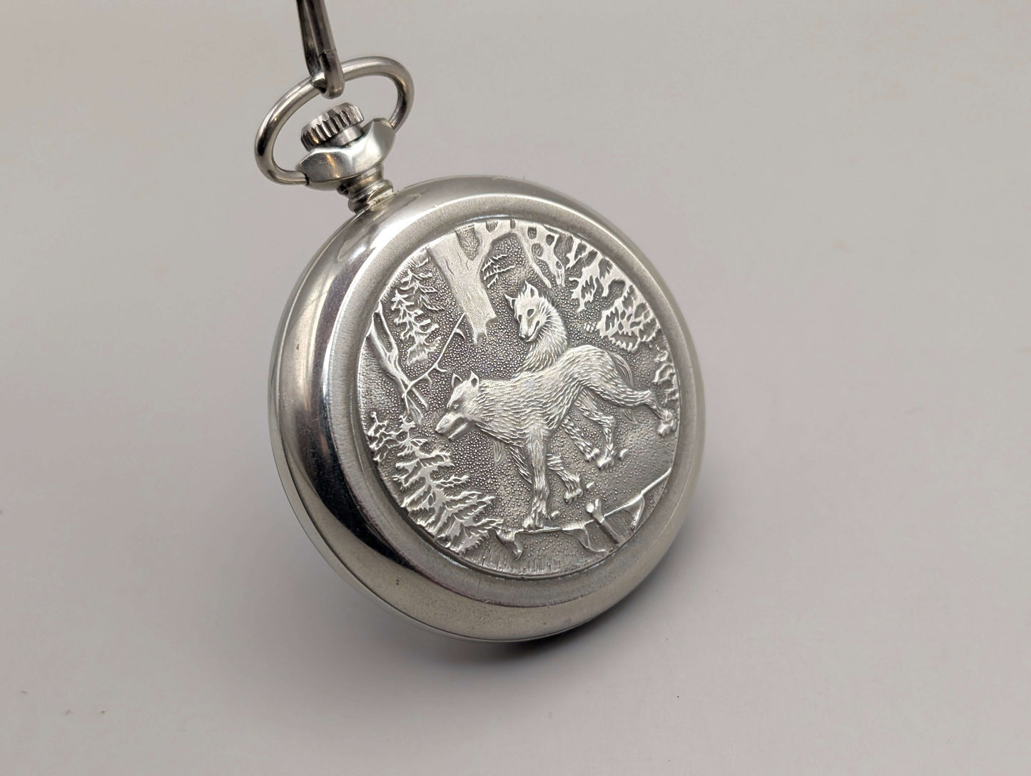 Silver-tone Molnija pocket watch with "Wolves in the Forest" engraving, circa 1980s, Soviet Union origin, nickel-plated brass.